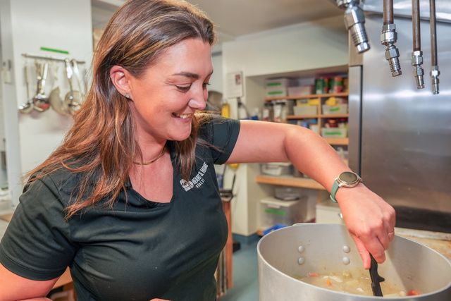 Meghan stirring a pot of soup in the Shelter Nova Scotia kitchen