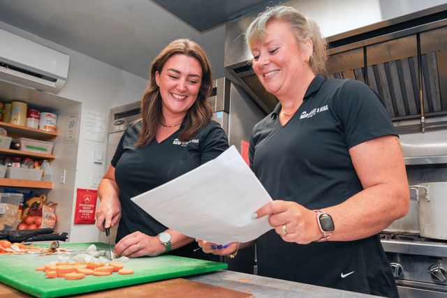 Meghan and Mary-Jane chopping vegetables together