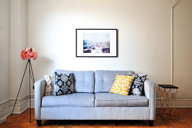 A bright, simply furnished living room with a grey sofa